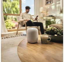 Slimme luidspreker op een ronde houten tafel in een woonkamer