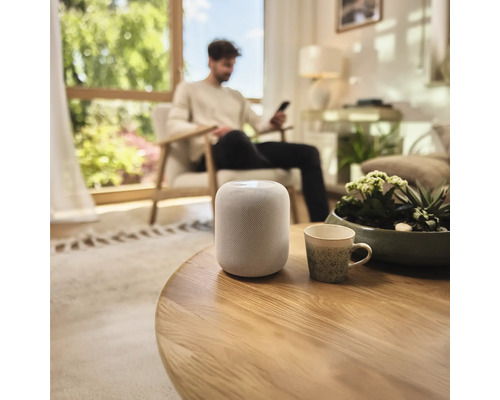 Luidspreker op een houten tafel in een lichte woonkamer