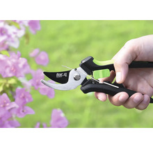 Een takkenschaar van het merk for.q in een hand voor bloemen