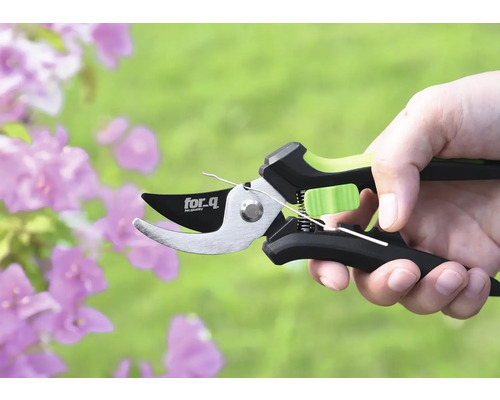 Een takkenschaar van het merk for.q in een hand voor bloemen