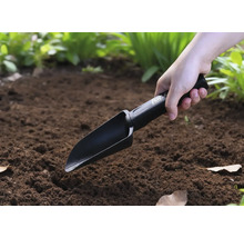 Iemand gebruikt een handgereedschap in de tuin.