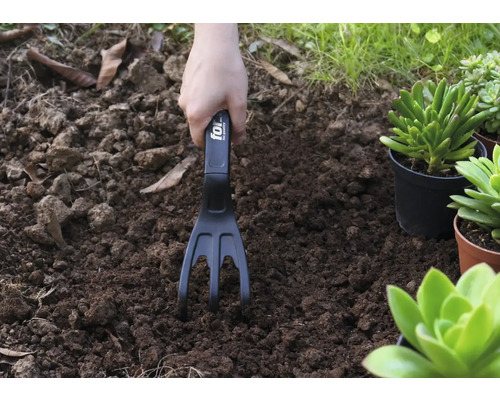 Tuinieren met een tuinkrabber in de aarde