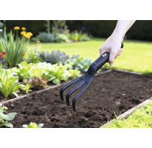 Tuinklauw in gebruik in een groentebed.