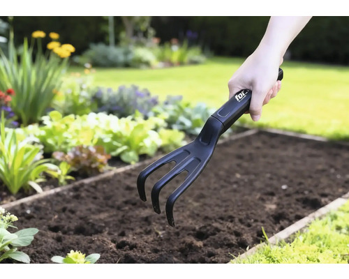 Tuinklauw in gebruik in een groentebed.