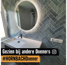 Badkamer met wastafel, spiegel en wandtegels in visgraatmotief