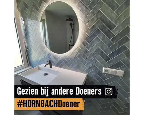 Badkamer met wastafel, spiegel en wandtegels in visgraatmotief