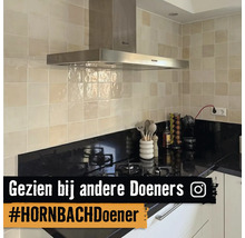 Keukenoverzicht met afzuigkap, tegelwand en kookplaat