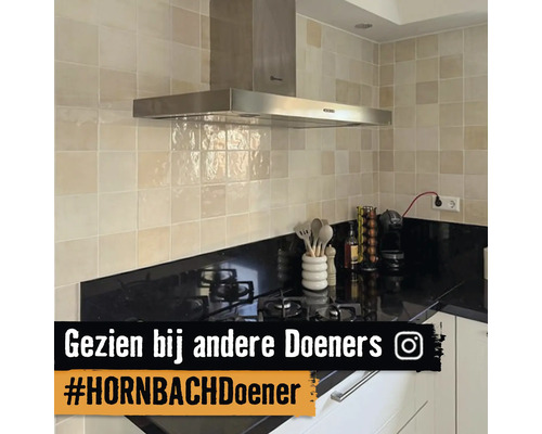 Keukenoverzicht met afzuigkap, tegelwand en kookplaat