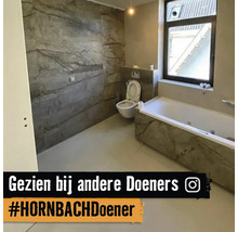 Badkamer met bad en toilet in grijze marmerlook