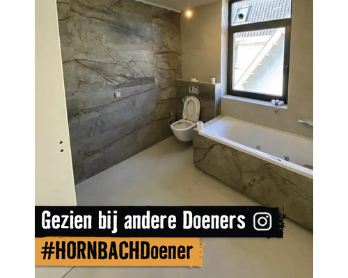 Badkamer met bad en toilet in grijze marmerlook