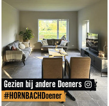 Woonkamer met banken, fauteuil, salontafel en televisie