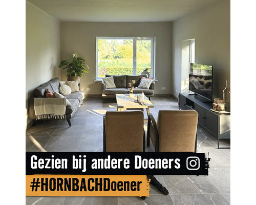 Woonkamer met banken, fauteuil, salontafel en televisie