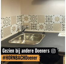 Keukenspoelbak met mozaïektegels aan de wand