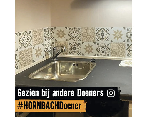 Keukenspoelbak met mozaïektegels aan de wand