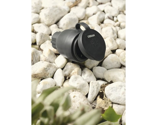 Osram Logo. Tuincontactdoos met open deksel op grind.