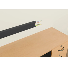 Kunststof kabelgoot met kabels aan een muur boven een bureau