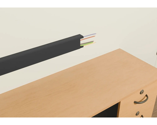 Kunststof kabelgoot met kabels aan een muur boven een bureau