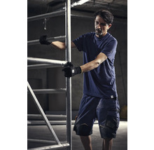 Man in werkkleding bedient een bouwsteiger.