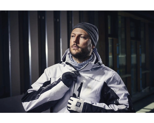 Man in werkkleding met capuchon, muts en handschoenen