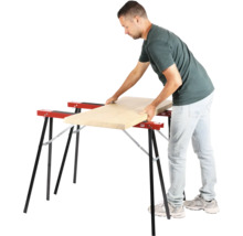 Man legt houten plank op twee schragen