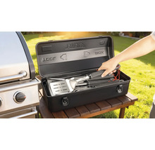 Barbecuebestekset in een zwarte opbergdoos naast een barbecue