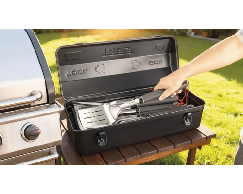 Barbecuebestekset in een zwarte opbergdoos naast een barbecue