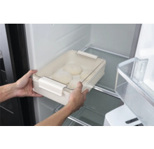 Persoon plaatst een deegkom met deksel in de koelkast