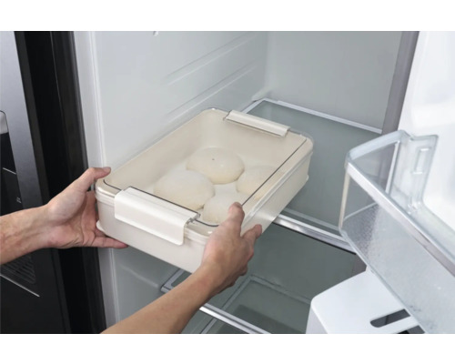 Persoon plaatst een deegkom met deksel in de koelkast