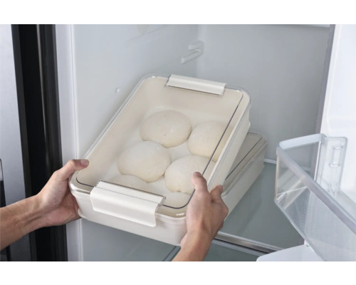 Deegbak met deegbollen in de koelkast