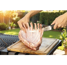 Bereiding van lamsrack op een houten plank met een Tenneker mes in de tuin.