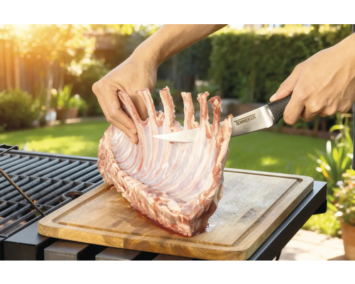 Bereiding van lamsrack op een houten plank met een Tenneker mes in de tuin.