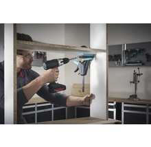 Een man monteert een plank met een accuschroevendraaier en een eenhandklem.