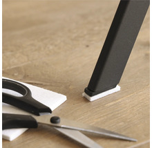 Stoelpoot met vilten glijder, vilten glijder en schaar op houten vloer