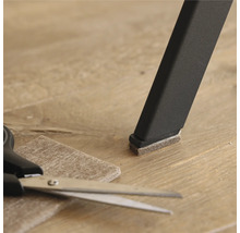 Stoelpoot met viltglijder, viltglijder en schaar op vloer