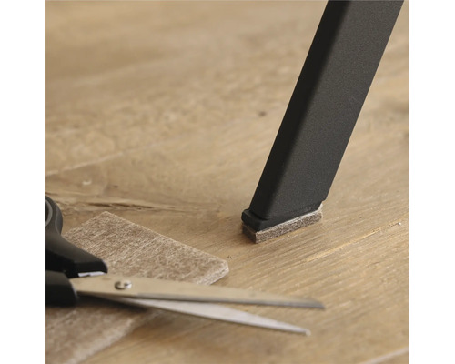 Stoelpoot met viltglijder, viltglijder en schaar op vloer