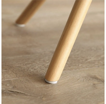 Detailopname van een houten meubelpoot met vloerbeschermer.