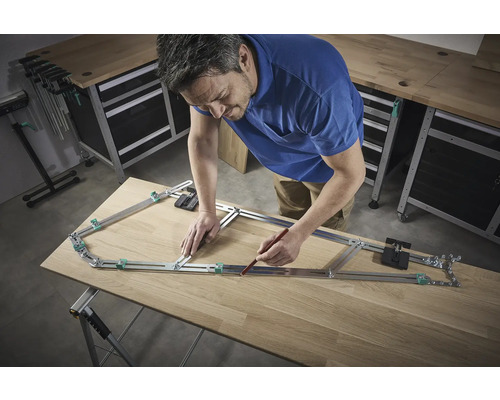 Een man gebruikt een profielmal om een vorm over te brengen op een houten plank.