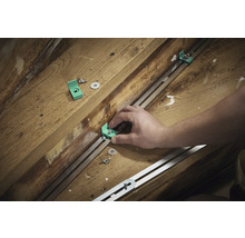 Montage van montagehoeken met schroeven en sluitringen op een metalen rail op een houten ondergrond