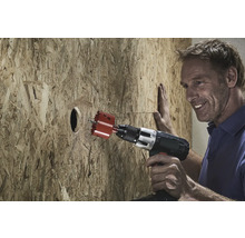 Man boort gat met gatzagen in houten plaat