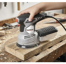 Een hand bedient een Pattfield excentrische schuurmachine op een houten plank.