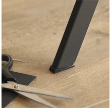 Meubelglijder onder een tafelbeen en een schaar om op maat te knippen