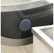 Detail van een wasmachine met een ronde, grijze afdichtingsplug