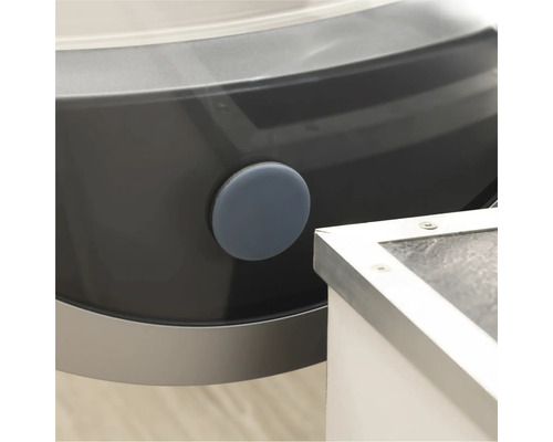 Detail van een wasmachine met een ronde, grijze afdichtingsplug