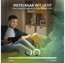 Man met tablet en vrouw met boek op een bank onder instelbaar licht