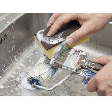 Reiniging van verfroller en kwast met een spons in de gootsteen.