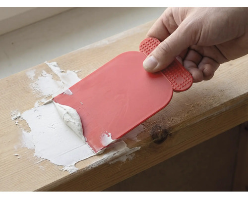 Ambachtsman gebruikt een plamuurmes om voegmiddel aan te brengen.