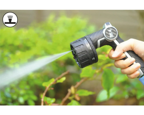 Hand houdt tuinslangspuitpistool vast tijdens het besproeien van planten