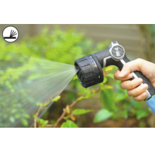 Persoon houdt een tuinspuit vast die water sproeit