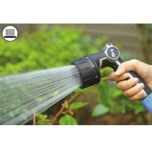 Hand houdt tuinspuit vast tijdens het besproeien