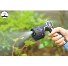 Hand houdt tuinspuit met straal vast